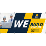 Large-format mesh banner printed by PGI Printing, showing two professionals in hard hats reviewing plans, with bold text “WE BUILD DREAMS” and blue-and-yellow corporate branding.